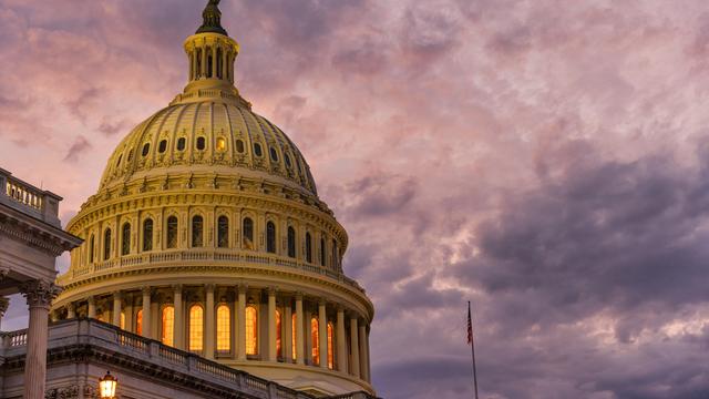 Blick auf das Capitol in den USA - den Sitz des Kongresses, in dem Sitzungen von Senat und Repräsentantenhaus stattfinden. Am Himmel sind düstere Wolken zu sehen. 