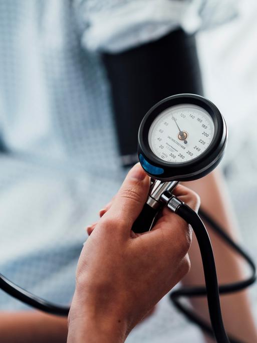 Ein Blutdruckmessgerät am Arm eines Patienten