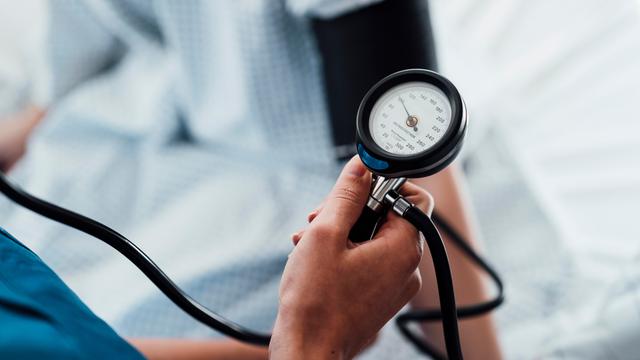 Ein Blutdruckmessgerät am Arm eines Patienten Ein Blutdruckmessgerät am Arm eines Patienten