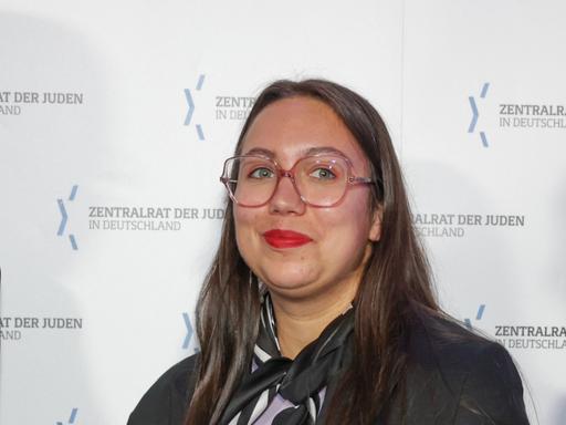 Ronya Othmann, Schriftstellerin, vor einer Werbewand