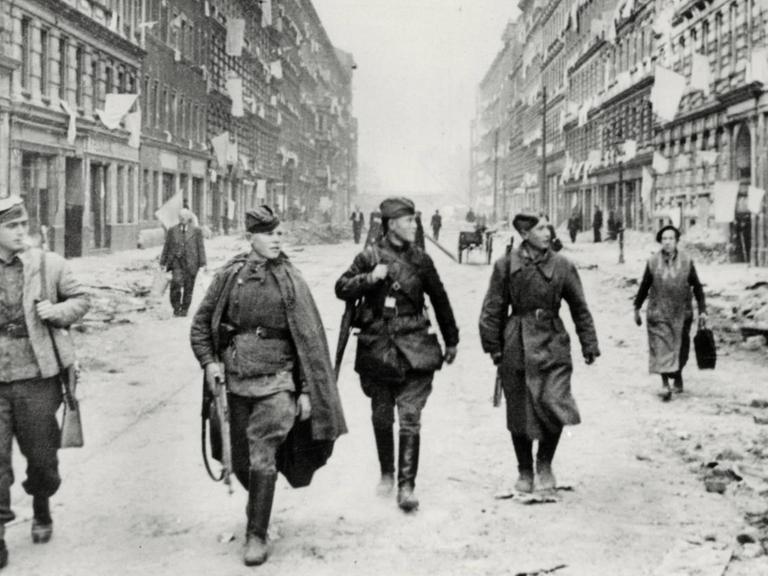 2. Weltkrieg / Eroberung von Berlin durch die Rote Armee, 16. April bis zur Kapitulation am 2. Mai 1945. Sowjetsoldaten ziehen durch eine Straße Berlins. Aus den Fenstern der Häuser hängen als Zeichen der Kapitulation weiße Fahnen. Foto, 1. Mai 1945. |