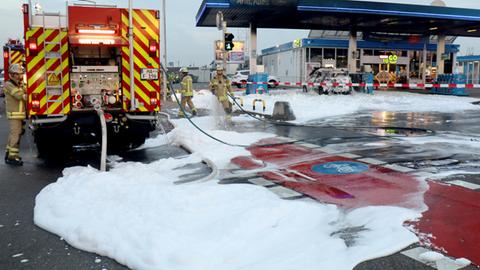 Löschschaum liegt nach dem Einsatz der Feuerwehr auf dem Gelände einer Tankstelle.