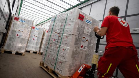 Ein Mitarbeiter vom Deutschen Roten Kreuz belädt einen Lastwagen Hilfsgütern.
