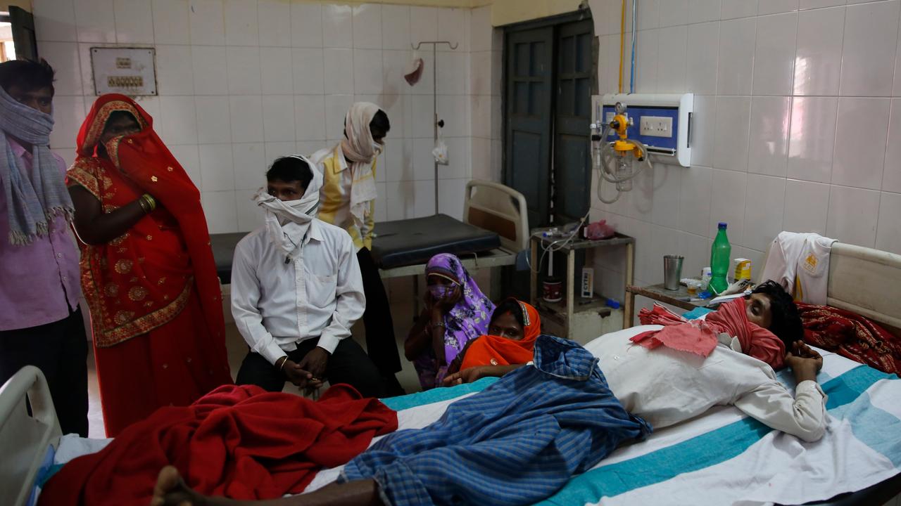 Familienangehörige stehen in einem Krankenhaus in Varanasi in Indien am Bett eines Patienten, der an Tuberkulose leidet. 