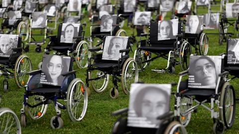 Die Aktionsgruppe NichtGenesen hat Rollstühle mit Bildern Betroffener vor dem Bundestag positioniert