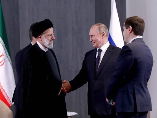 Der iranische Präsident Ebrahim Raisi und Wladimir Putin schütteln sich die Hände bei einem Treffen in Usbekistan, 2022.
