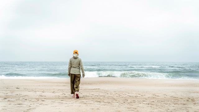 Frau spaziert an einem Strand (Symbolbild) Frau spaziert an einem Strand (Symbolbild)
