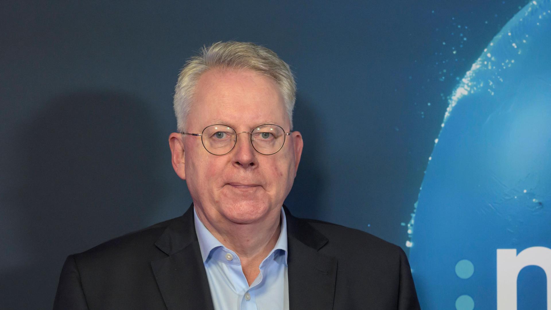 Peter Limbourg, Intendant Deutsche Welle, steht vor blauem Hintergrund. 