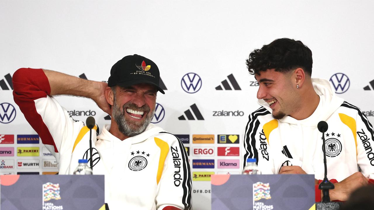 Pressekonferenz vor dem Spiel in Griechenland: Bundestrainer Jürgen Klopp (l) und Aleksandar Pavlovic stellen sich den Fragen der Journalisten. Sie tragen beide Deutschland-Trikots und lachen vergnügt.