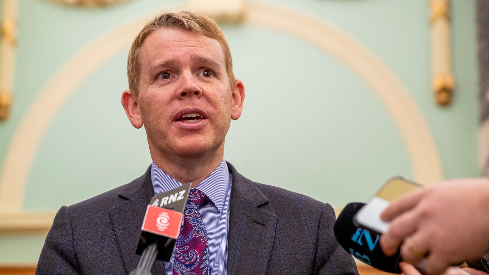 Der neuseeländische Politiker Chris Hipkins steht vor mehreren Mikrofonen und spricht. Der neuseeländische Politiker Chris Hipkins steht vor mehreren Mikrofonen und spricht.