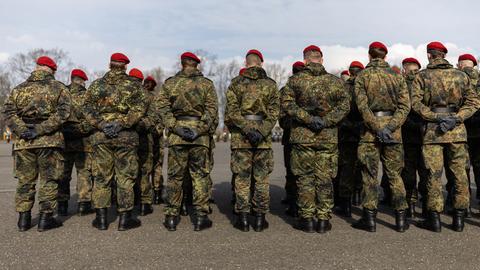 Mehrere Soldaten stehen auf einem Platz in einer Kaserne. 