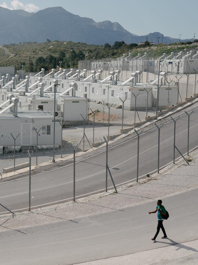Eine eingezäunte Containersiedlung, im Hintergrund sind die Berge zu sehen.
