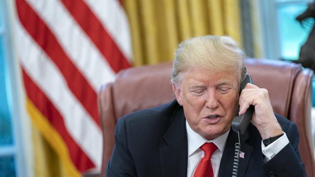 Donald Trump hat einen Telefon-Hörer in der Hand und spricht.