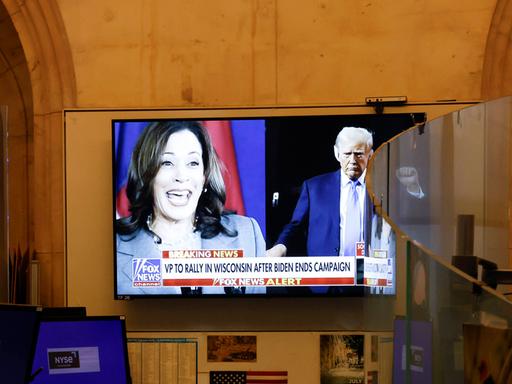 Auf einem TV-Bildschirm sind Kamala Harris und Donald Trump zu sehen. 