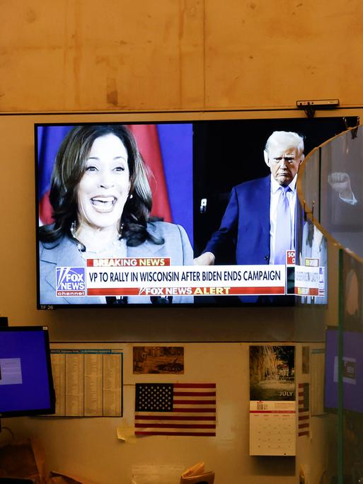 Auf einem TV-Bildschirm sind Kamala Harris und Donald Trump zu sehen. 