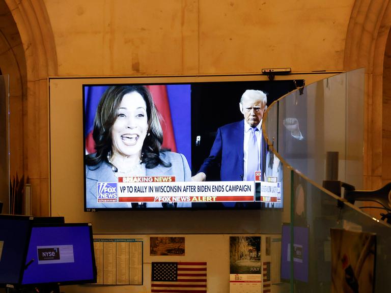 Auf einem TV-Bildschirm sind Kamala Harris und Donald Trump zu sehen. 