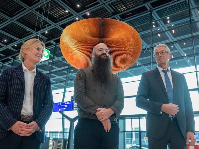 Stefanie Pudwitz (l-r), Leitende Exekutiv-Vizepräsidentin für Unternehmensinfrastruktur bei Fraport AG, der Künstler Julius von Bismarck und Fraport Vorstandsvorsitzender Stefan Schulte im neuen Terminal 3 