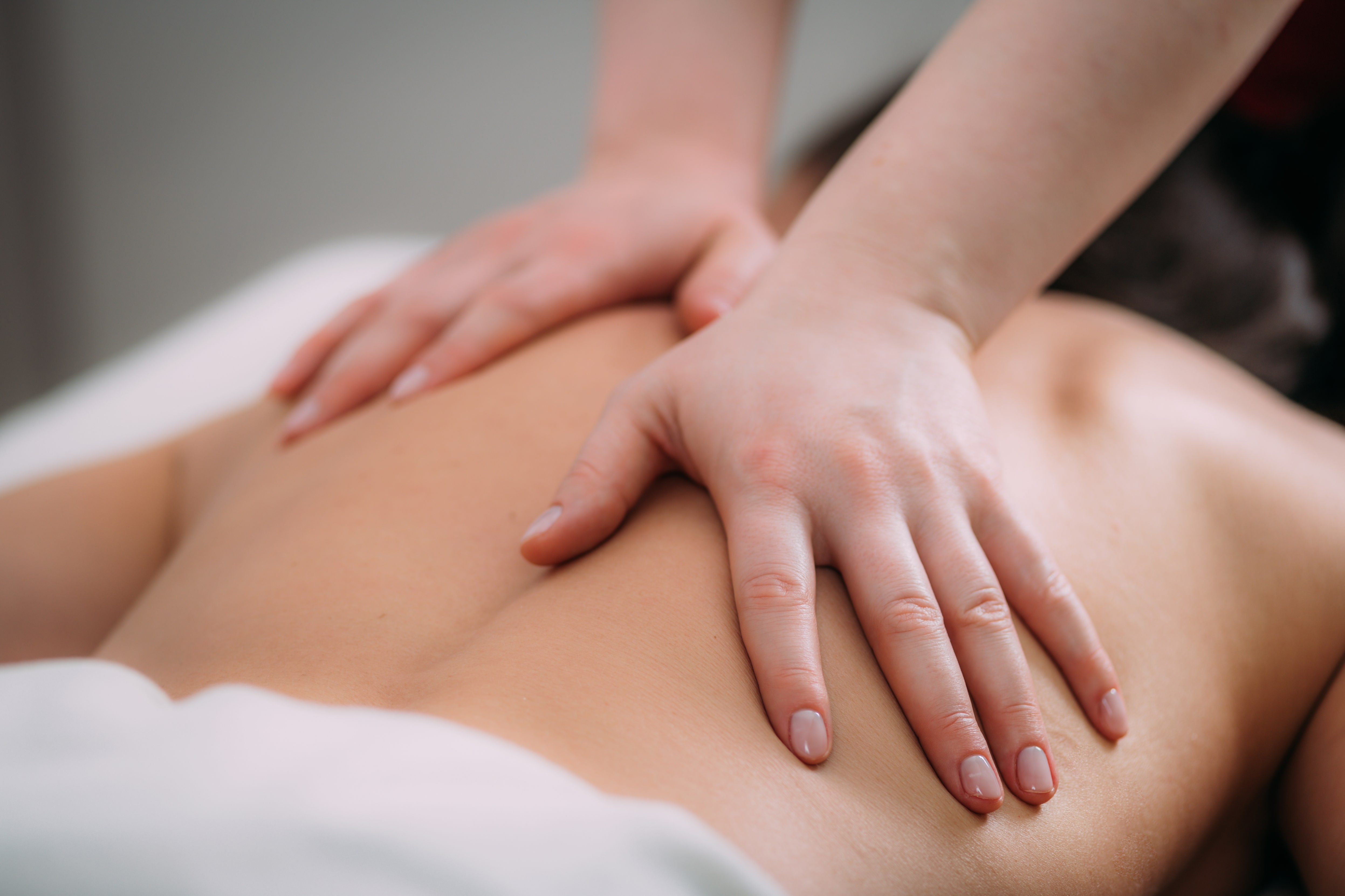 Eine Person auf einer Liege bekommt eine Rückenmassage