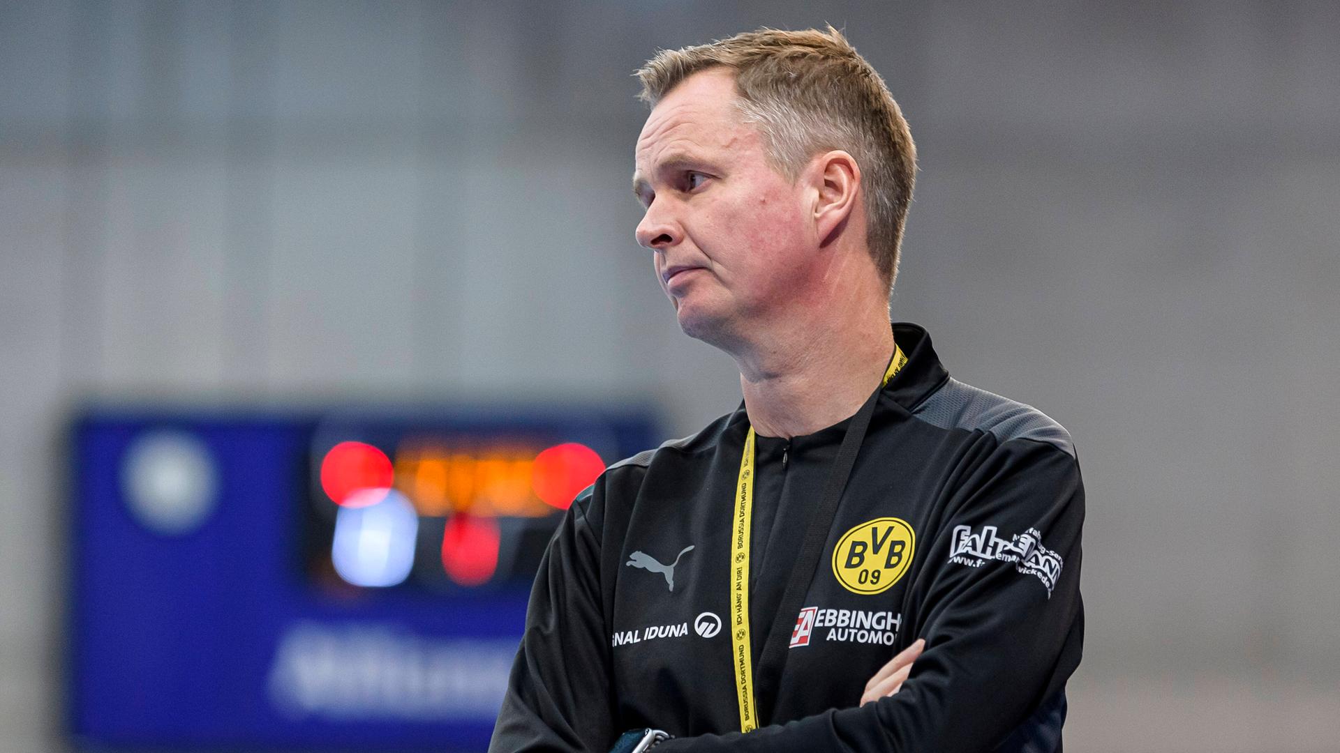 Trainer Andre Fuhr blickt mit verschränkten Armen auf das Spielfeld.
