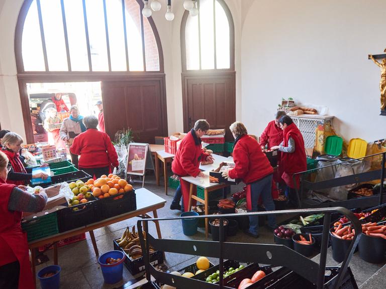 Ehrenamtliche Helfe der Tafel Laib und Seele" 2018 bei der Essensausgabe in einem Vorraum der Berliner Advent-Zachäus Kirche. 