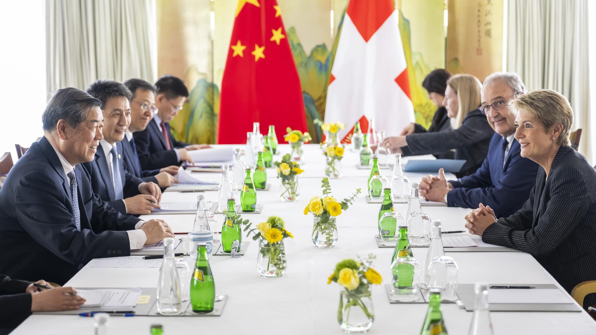 An einem Konferenztisch sitzen mehrere Personen: links die chinesische Delegation, rechts Vertreter der Schweiz, am Tischende die Nationalflaggen. An einem Konferenztisch sitzen mehrere Personen: links die chinesische Delegation, rechts Vertreter der Schweiz, am Tischende die Nationalflaggen.