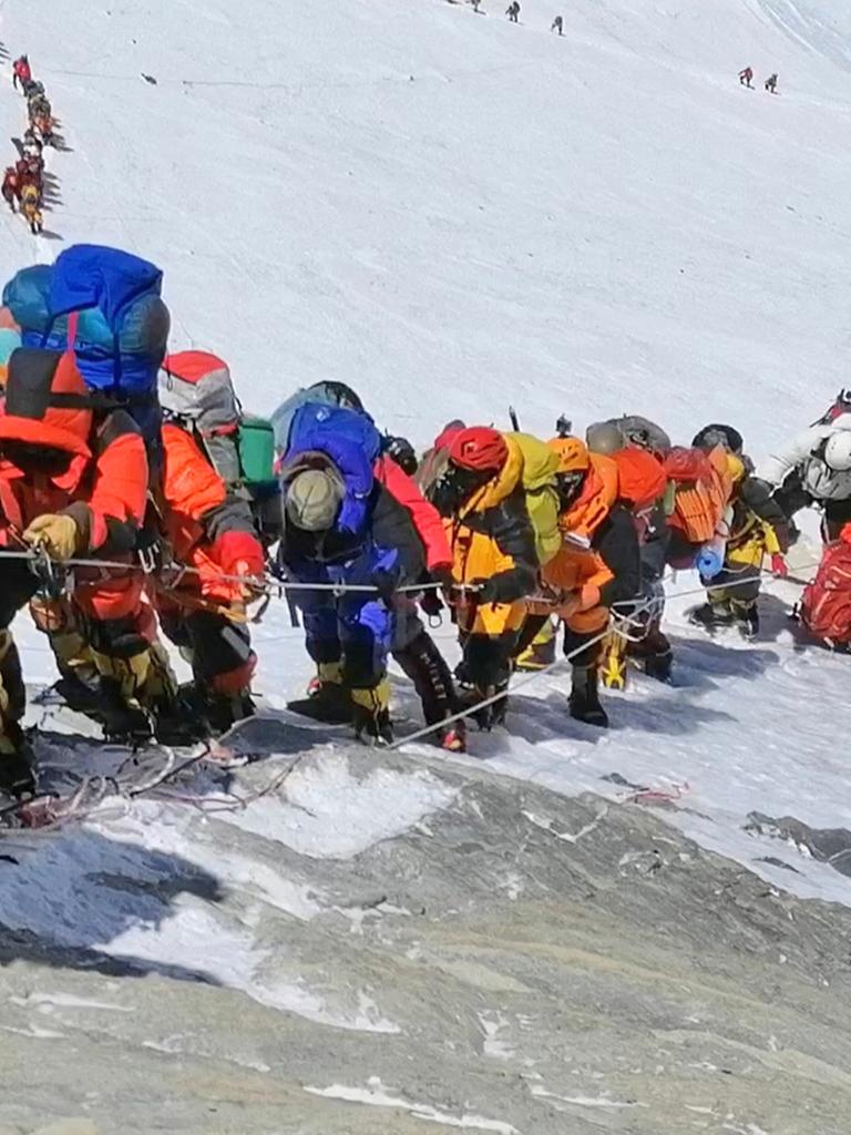 Eine lange Schlange von Menschen steigt den Mount Everest hinauf.