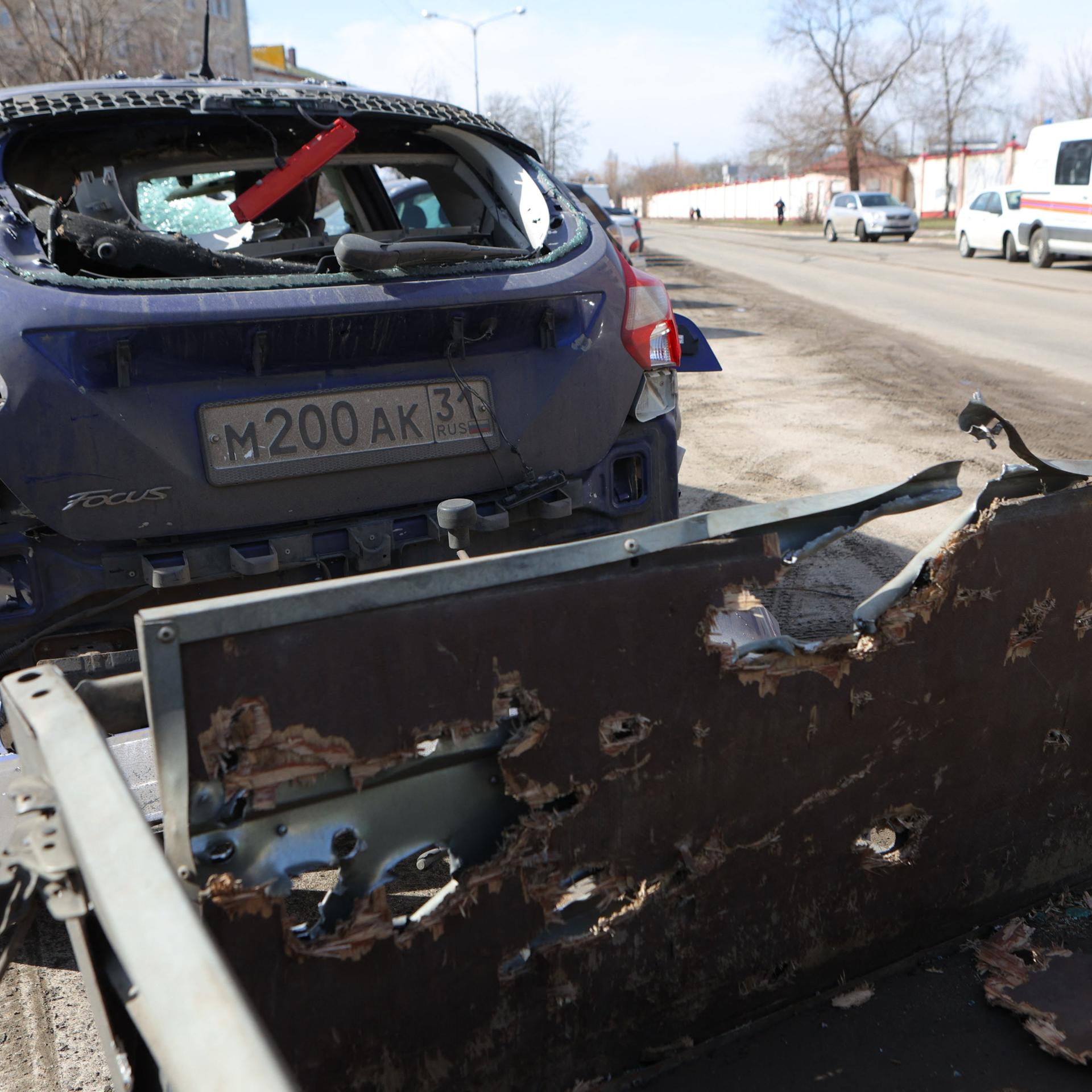 Zwei von einem ukrainischen Angriff zerstörte Autos stehen am Straßenrand in Belgorod.