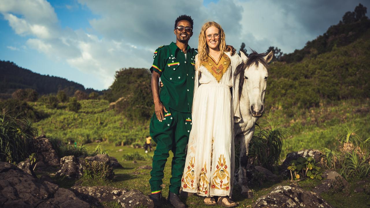 Valerie Seitz und ihre Mann Abiy stehen Arm in Arm zusammen mit ihrem Pferd in einem grünen Tal.