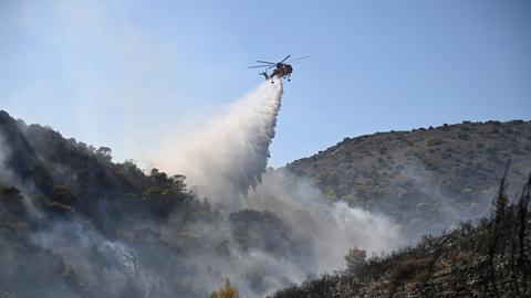 Ein Löschhubschrauber über einem Waldbrand.