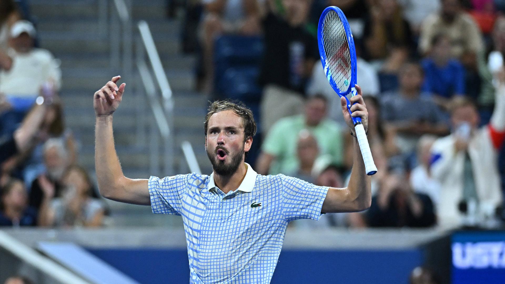 Das Foto zeigt den russischen Tennis-Spieler Medwedew. Er hält einen Arm hoch.