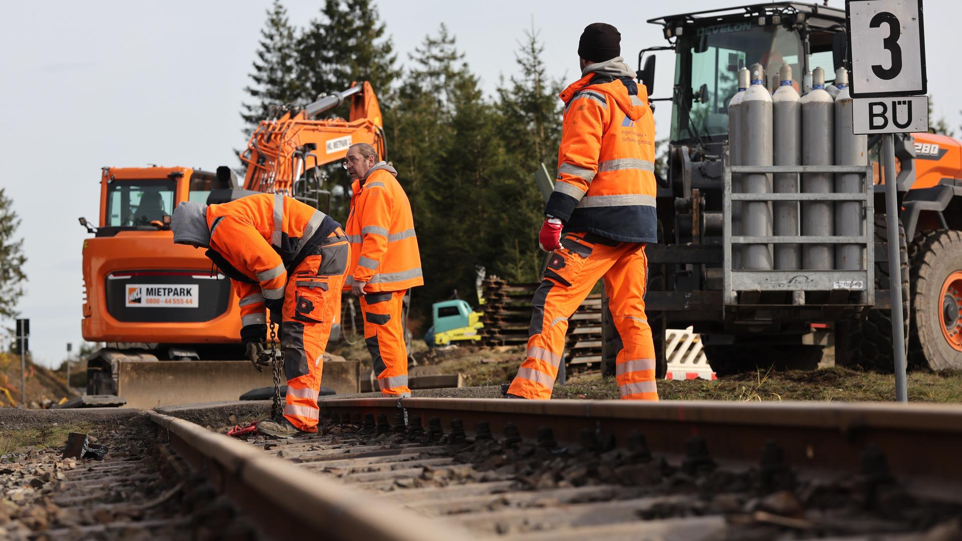 Bauarbeiter arbeiten an Schienen. Sie haben auch eine Bagger dabei. Bauarbeiter arbeiten an Schienen. Sie haben auch eine Bagger dabei.