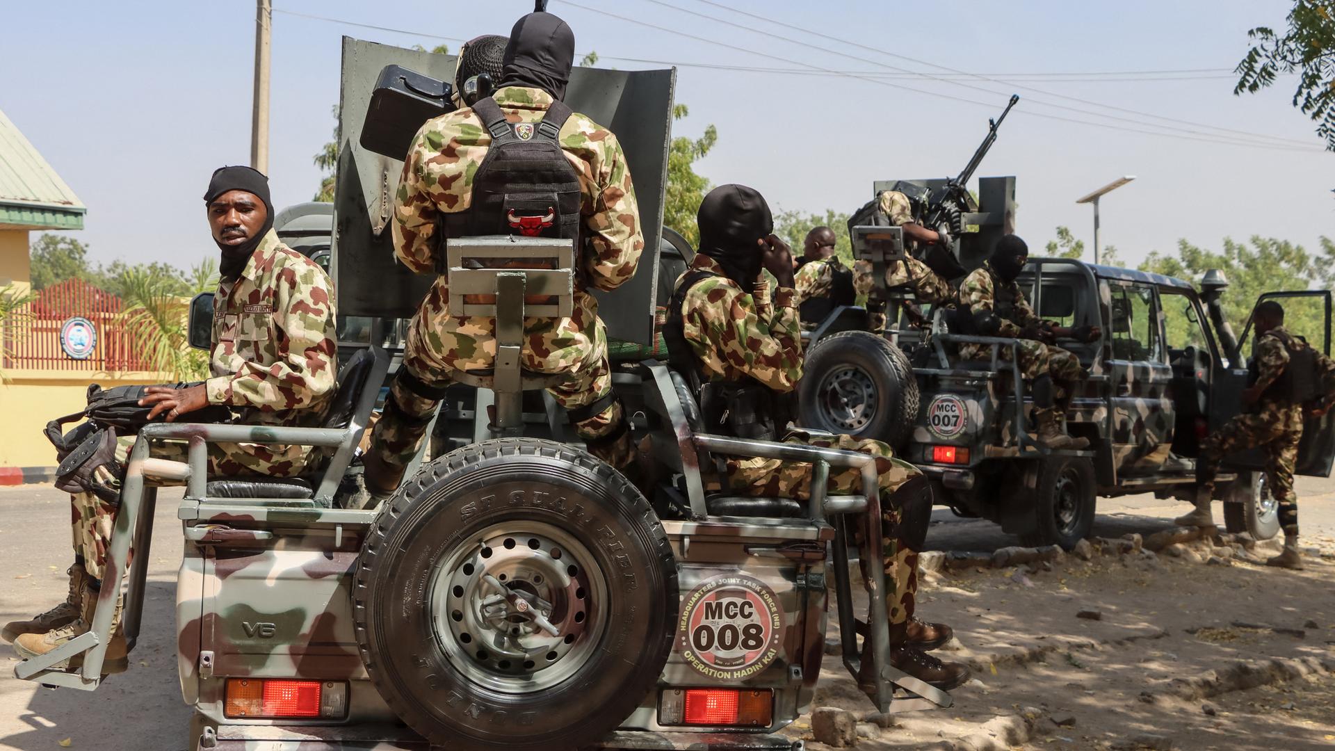 Nigerianische Soldaten mit Waffen auf mehreren Pick-ups