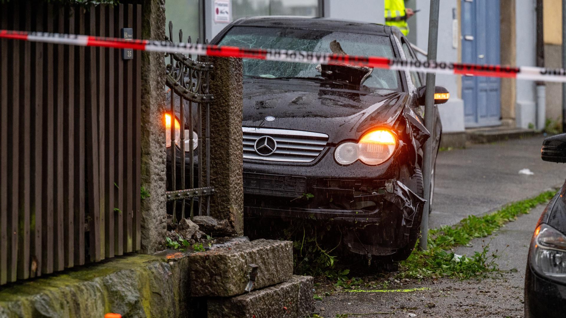 Ein beschädigtes Auto steht auf einem Gehweg. 