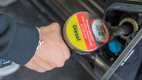 Ein Mann tankt an einer Tankstelle Diesel von Total.