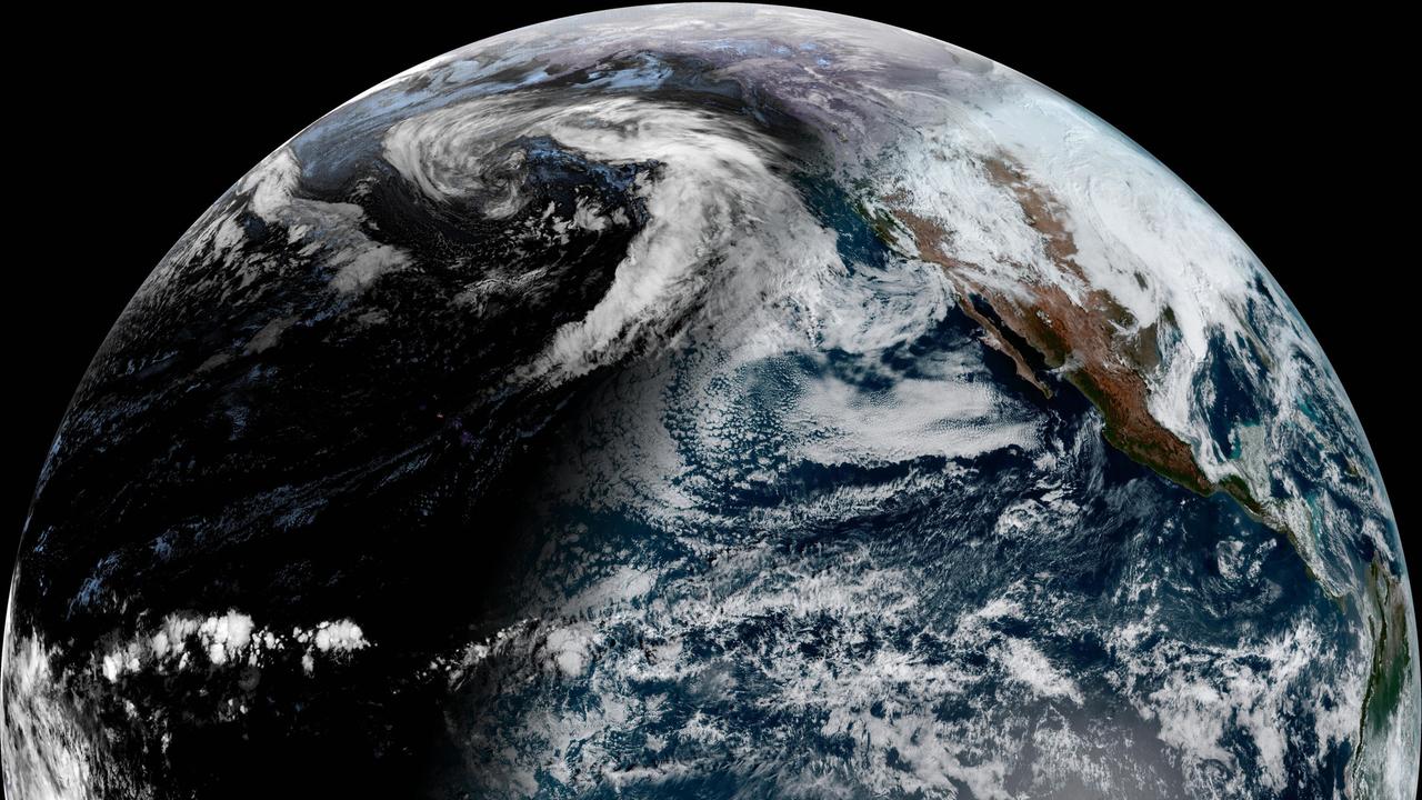 Das Bild zeigt eine Aufnahme der Erde aus dem Weltraum. Der blaue Planet ist von weißen Wolken umhüllt.