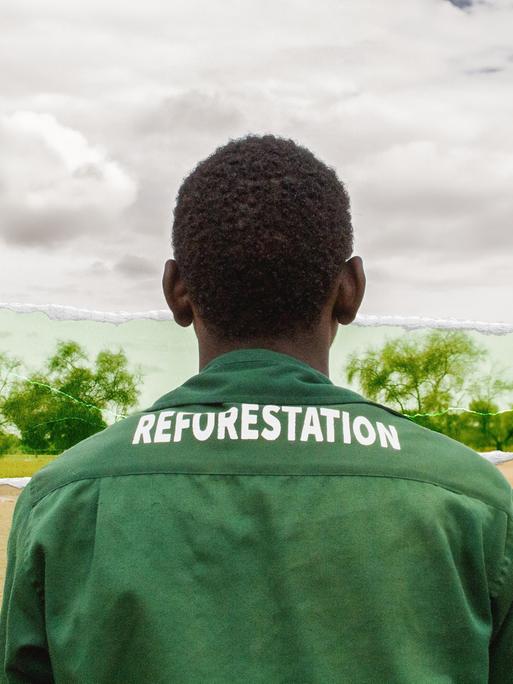 Ein Mitarbeiter der "Großen Grünen Mauer" mit einem Overall, auf dem das Wort "Reforestation" zu lesen ist