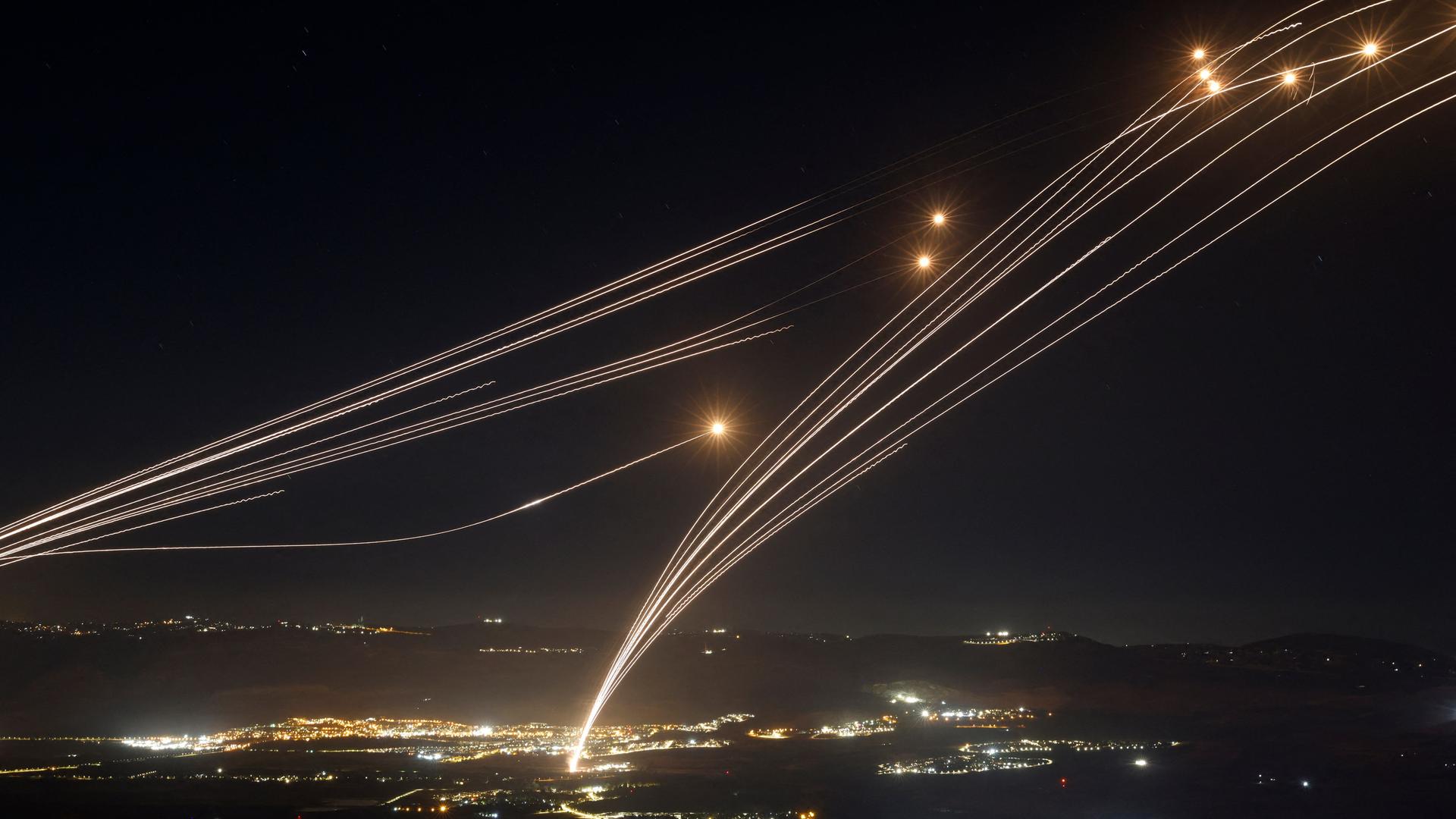 Raketen werden vom israelischen Luftabwehrsystem über einer Stadt abgefangen.