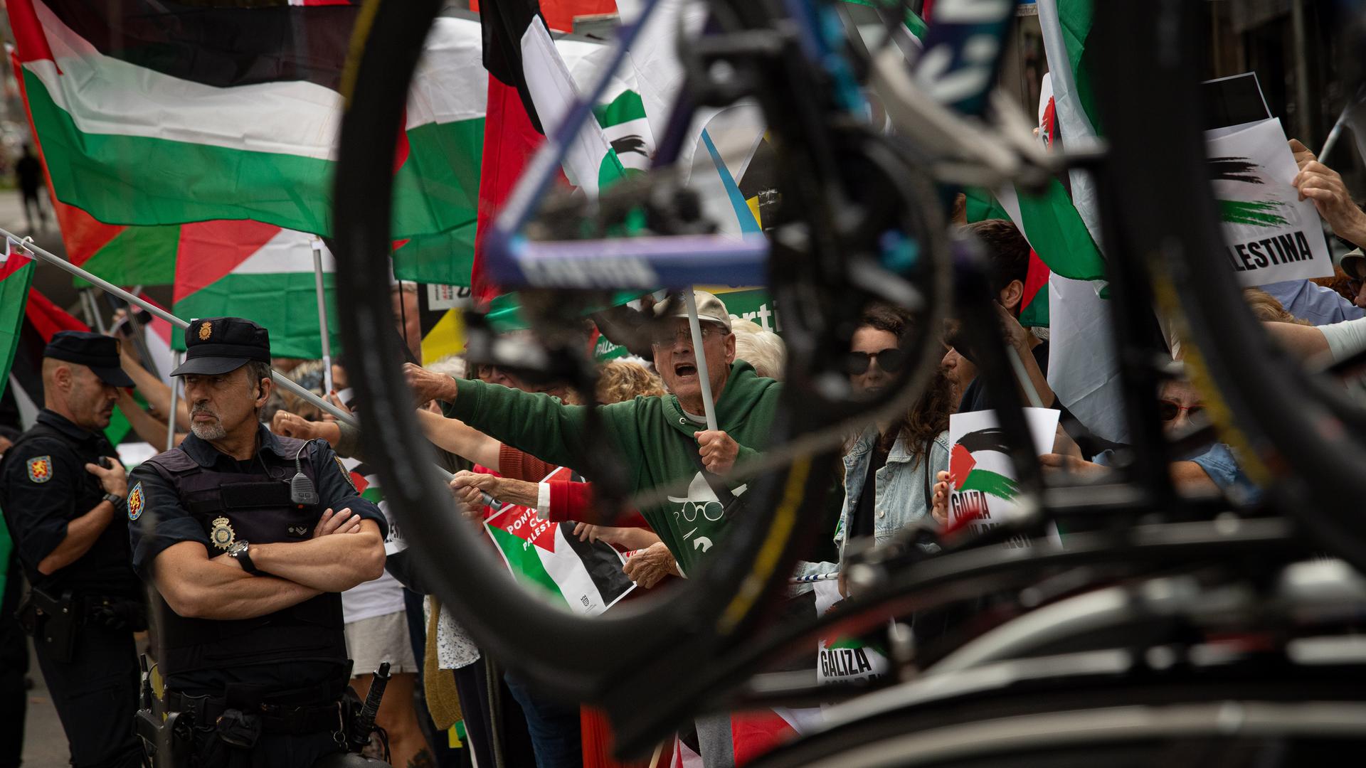 Demonstranten schwenken palästinensische Fahnen während einer Kundgebung gegen den Gaza-Krieg anlässlich des spanischen Radrennens Vuelta. 