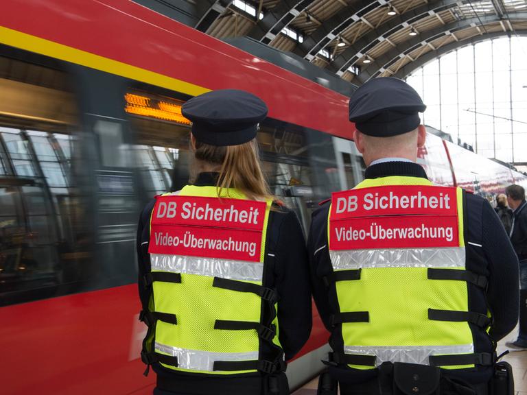 Sicherheitsmitarbeiter der Deutschen Bahn gehen 2016 bei einem Pressetermin in Berlin mit Spezialwesten mit der Aufschrift «DB Sicherheit Videoüberwachung» und einer daran angebrachten Mini-Kamera über einen Bahnsteig im Bahnhof Alexanderplatz. 