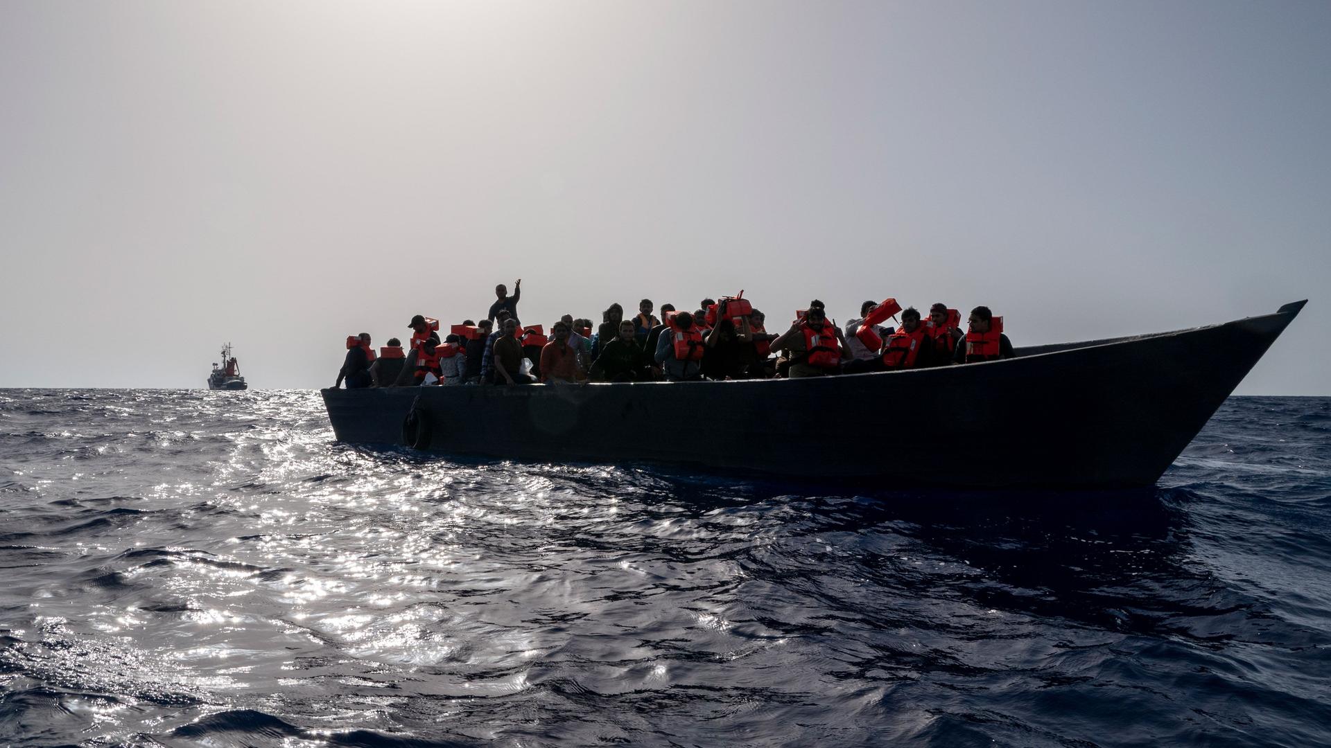 Menschen sitzen in einem überfüllten Boot, bevor sie von Crew-Mitglieder des Rettungsschiffes «Humanity 1» der Organisation SOS Humanity gerettet werden.