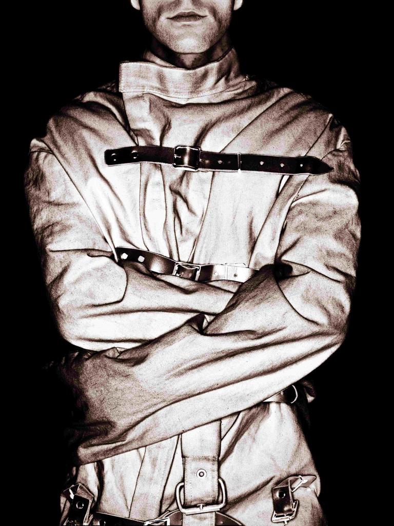 Schwarz-Weiß-Bild eines Manns mit Zwangsjacke