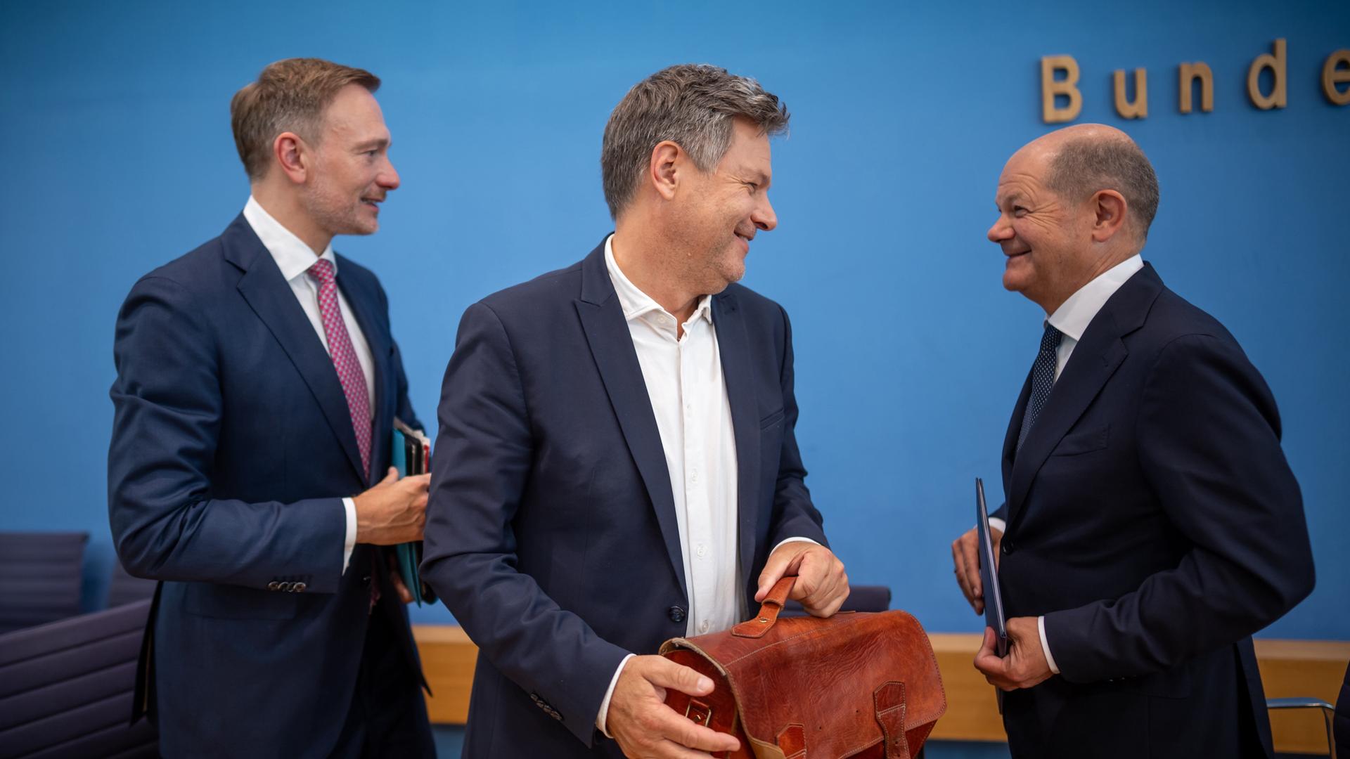 Bundeskanzler Olaf Scholz (SPD, r-l), Robert Habeck (Bündnis 90/Die Grünen), Bundesminister für Wirtschaft und Klimaschutz, und Christian Lindner (FDP), Bundesminister der Finanzen, nehmen an einer Pressekonferenz zum Haushaltsplan 2025 teil.