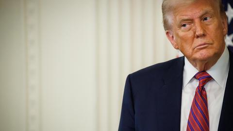 US-Präsident Donald Trump in Anzug und mit Krawatte vor einem hellen Hintergrund schaut skeptisch zur Seite