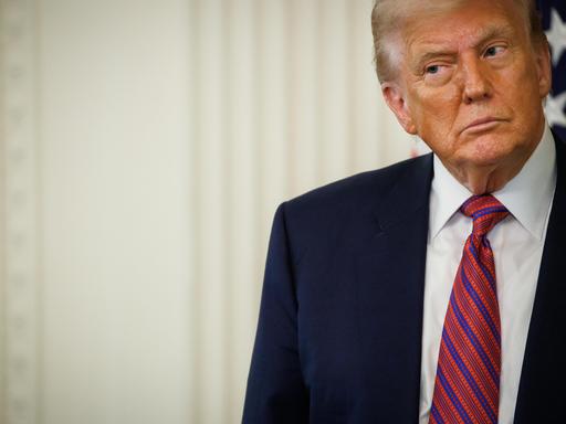 US-Präsident Donald Trump in Anzug und mit Krawatte vor einem hellen Hintergrund schaut skeptisch zur Seite