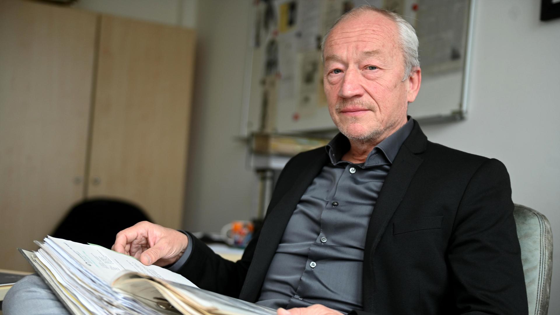 Ermittler Helmut Eigner sitzt am 05.04.2022 in seinem Büro und hat auf seinem Schoß einen Aktenordner