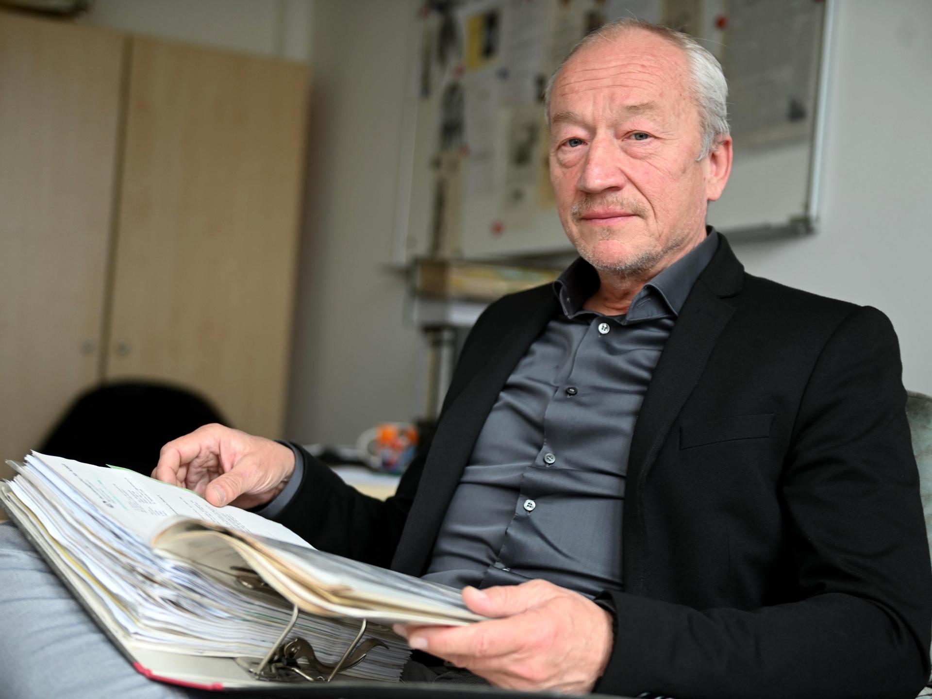 Ermittler Helmut Eigner sitzt am 05.04.2022 in seinem Büro und hat auf seinem Schoß einen Aktenordner