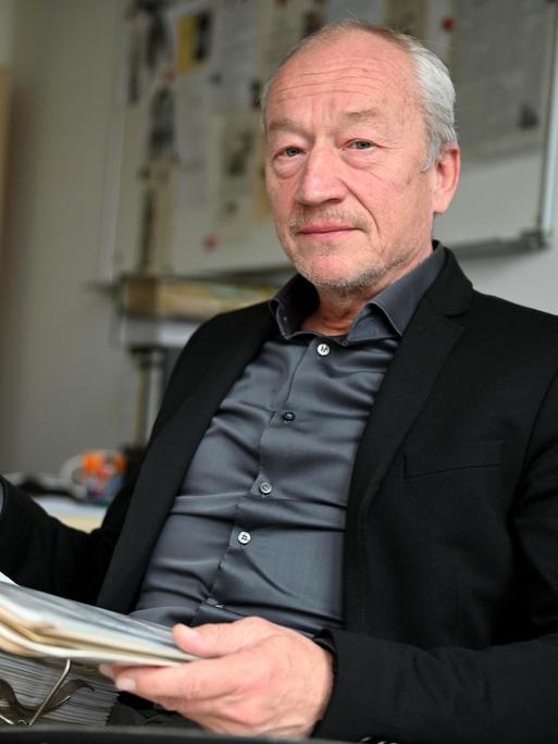 Ermittler Helmut Eigner sitzt am 05.04.2022 in seinem Büro und hat auf seinem Schoß einen Aktenordner