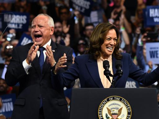 Kamala Harris und Tim Walz stehen bei einer Wahlkampfverantsltung der US-Demokraten in Philadelphia lachend auf dem Podium.