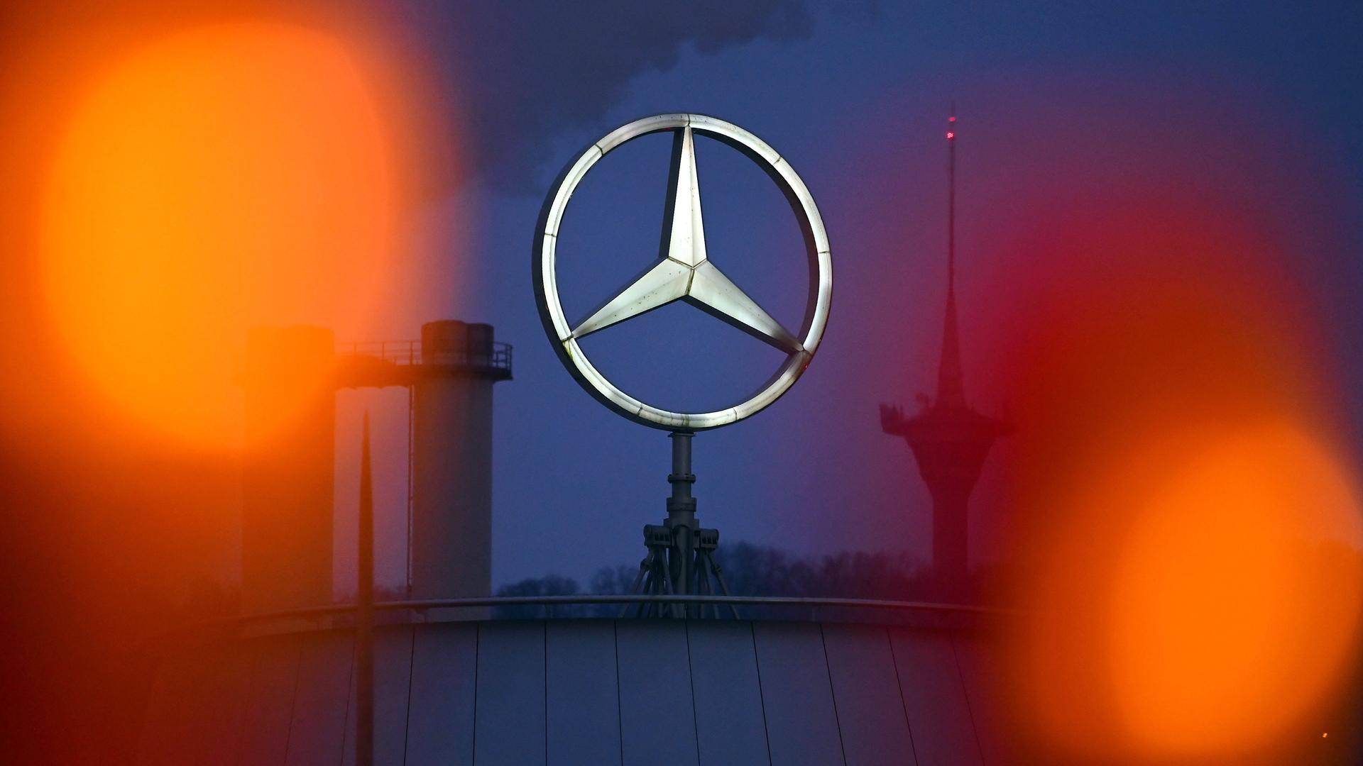 Mercedes-Stern leuchtet am Abend vor der Mercedes-Benz Group AG Zentrale in Stuttgart Untertuerkheim.