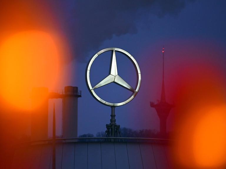 Mercedes-Stern leuchtet am Abend vor der Mercedes-Benz Group AG Zentrale in Stuttgart Untertuerkheim.